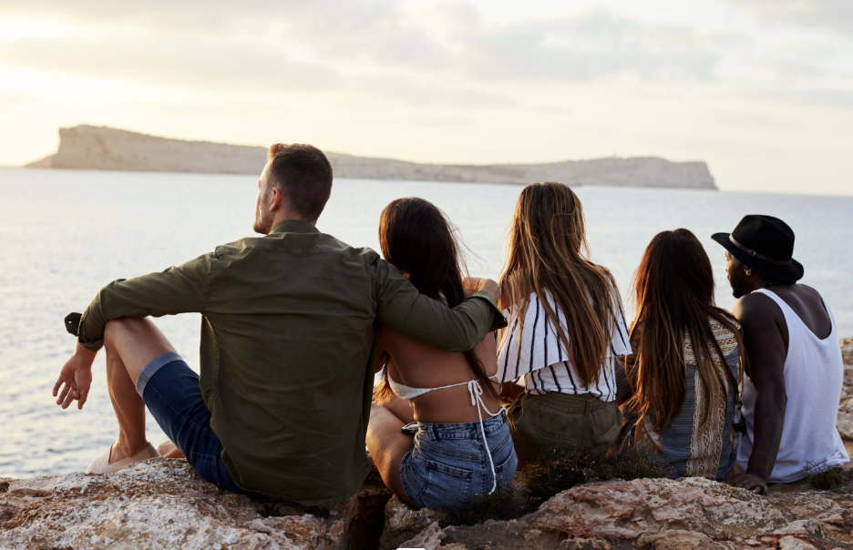 Photo of people sitting reflectively by the water.